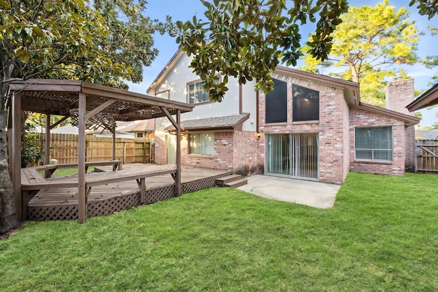 rear view of house with a deck, a lawn, and a patio