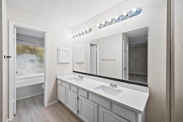 bathroom featuring toilet, vanity, a textured ceiling, and hardwood / wood-style floors