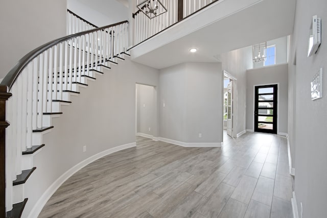 foyer featuring a chandelier, a high ceiling, and light hardwood / wood-style flooring