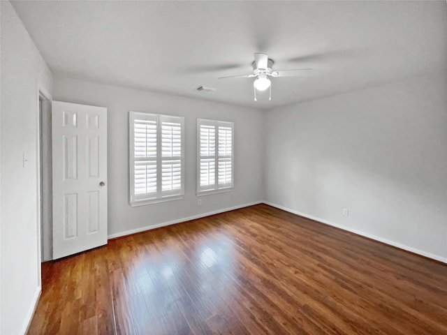 unfurnished room featuring dark wood-type flooring and ceiling fan