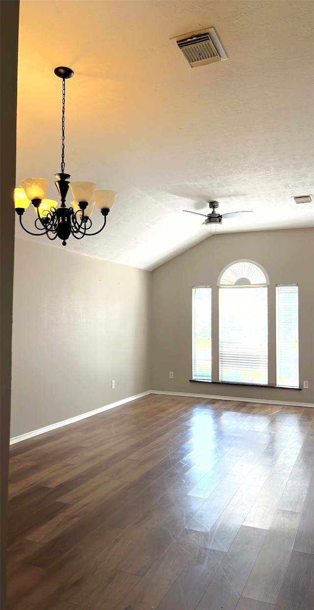 spare room with a textured ceiling, ceiling fan with notable chandelier, vaulted ceiling, and dark hardwood / wood-style flooring