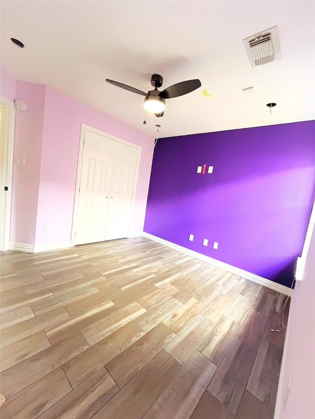 unfurnished bedroom featuring a closet, ceiling fan, and light wood-type flooring