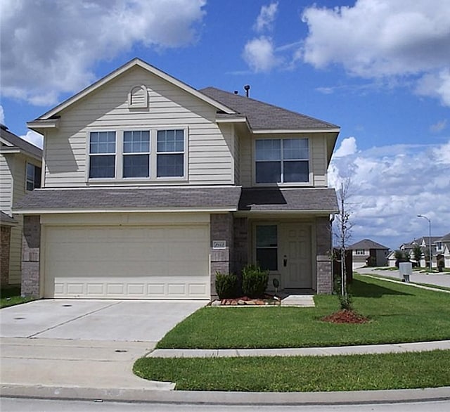 view of property with a garage and a front lawn