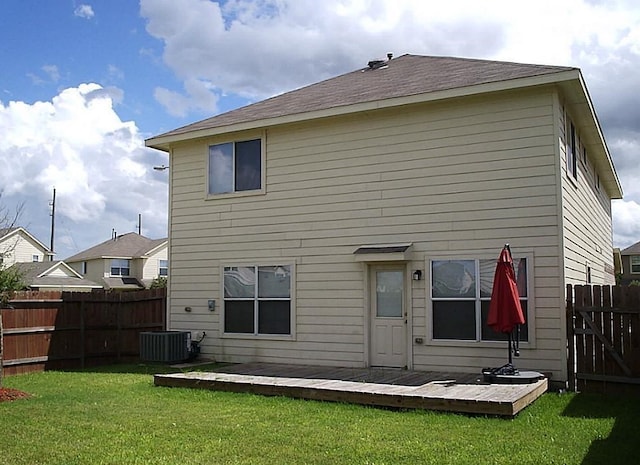 rear view of house with a yard and a wooden deck