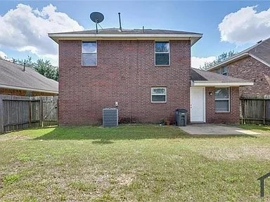 rear view of house featuring a yard, central AC unit, and a patio area