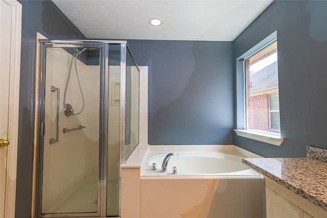 bathroom featuring vanity, a textured ceiling, and shower with separate bathtub