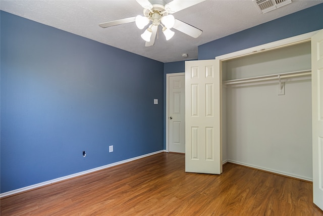 unfurnished bedroom with a closet, ceiling fan, wood-type flooring, and a textured ceiling