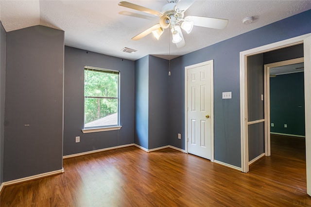 unfurnished bedroom with hardwood / wood-style floors, vaulted ceiling, a textured ceiling, and ceiling fan