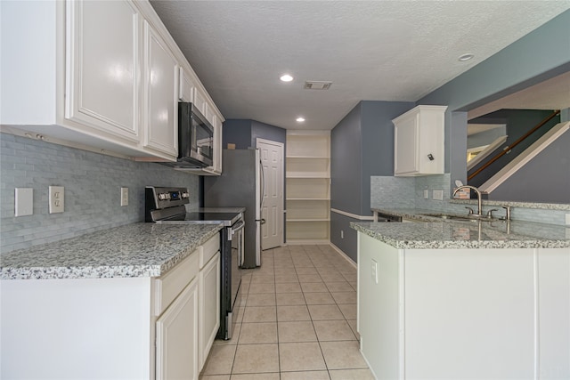 kitchen featuring decorative backsplash, sink, white cabinets, appliances with stainless steel finishes, and light stone counters