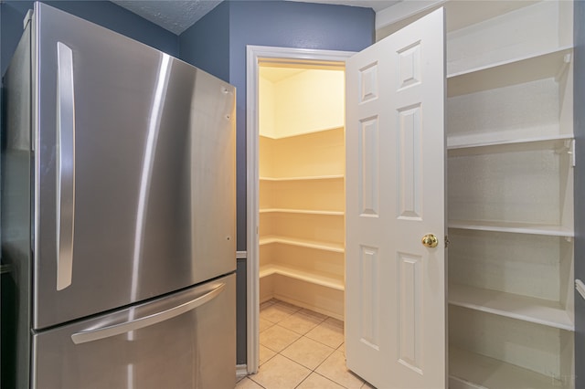 kitchen with stainless steel fridge and light tile patterned floors