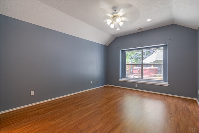 spare room featuring ceiling fan, a textured ceiling, lofted ceiling, and hardwood / wood-style floors