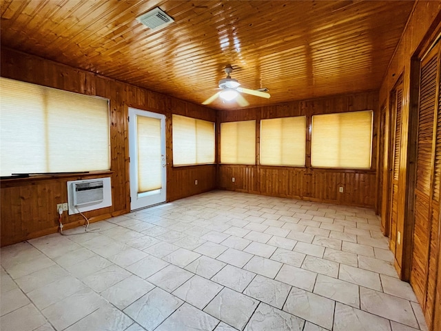 empty room with wood ceiling, wooden walls, a wall unit AC, and ceiling fan