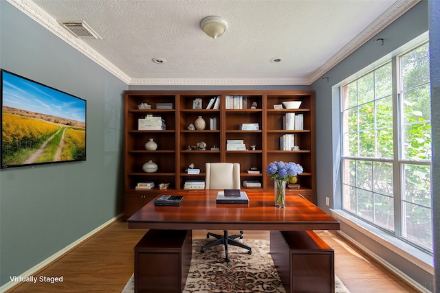 office space featuring ornamental molding, hardwood / wood-style floors, and a textured ceiling