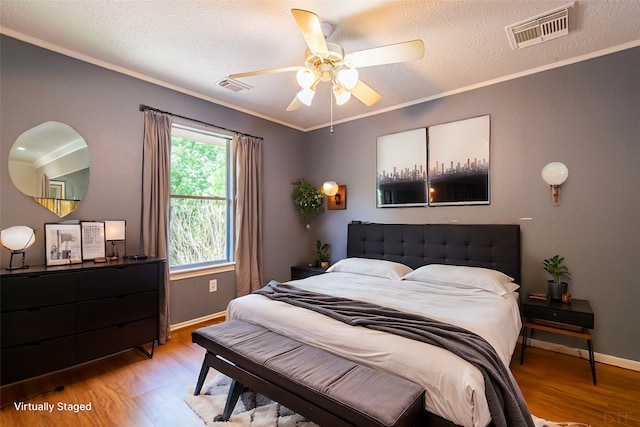 bedroom featuring crown molding, wood-type flooring, a textured ceiling, and ceiling fan