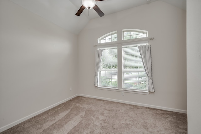 carpeted empty room with vaulted ceiling, a healthy amount of sunlight, and ceiling fan