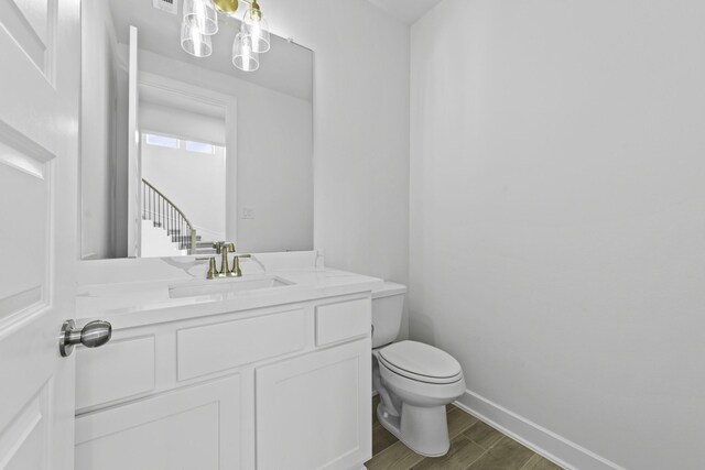 bathroom featuring wood-type flooring, vanity, and toilet