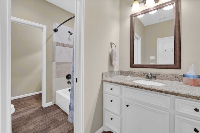 full bathroom featuring tiled shower / bath combo, vanity, and toilet