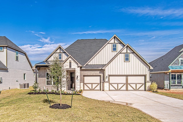 view of front of property featuring a garage, a front yard, and cooling unit