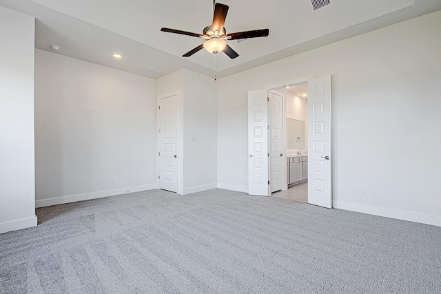 unfurnished bedroom featuring light carpet, ceiling fan, and ensuite bathroom