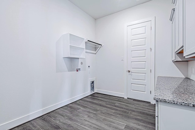 laundry area featuring dark hardwood / wood-style flooring, washer hookup, electric dryer hookup, and cabinets