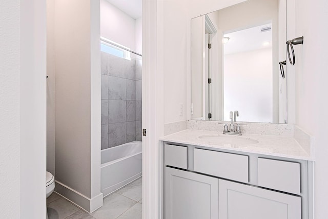 full bathroom with tiled shower / bath, tile patterned floors, vanity, and toilet