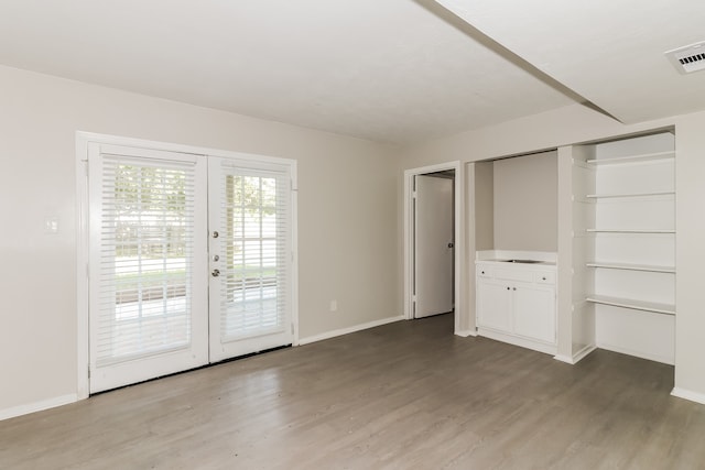 interior space with a closet, hardwood / wood-style flooring, access to exterior, and french doors