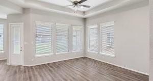 empty room featuring a tray ceiling, hardwood / wood-style flooring, and ceiling fan