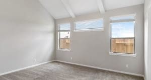 unfurnished room featuring carpet flooring, a healthy amount of sunlight, and lofted ceiling with beams