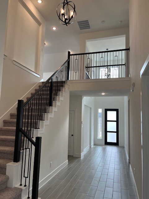 foyer entrance with a chandelier and a high ceiling