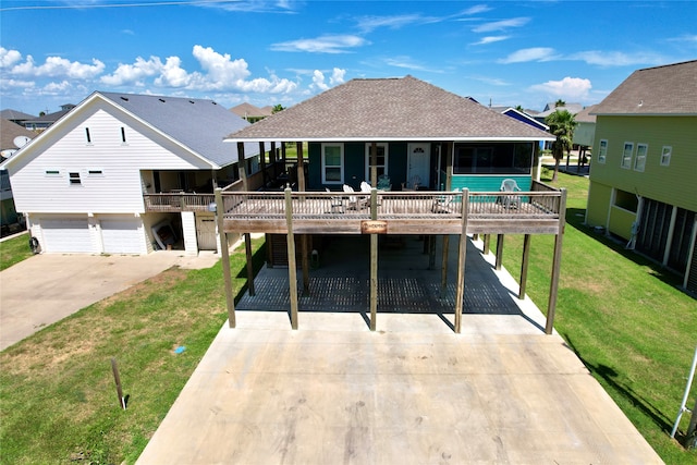 back of house featuring a yard, a garage, and a carport