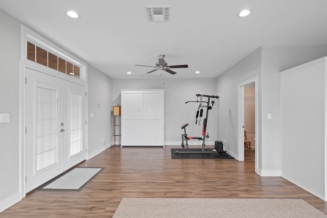 workout room featuring french doors, hardwood / wood-style flooring, and ceiling fan