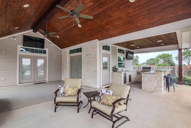 view of patio featuring an outdoor kitchen, grilling area, ceiling fan, french doors, and an outdoor wet bar