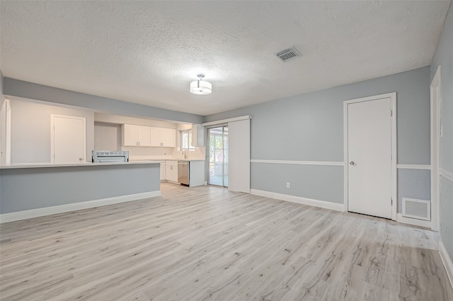 unfurnished living room featuring sink, a textured ceiling, and light hardwood / wood-style flooring