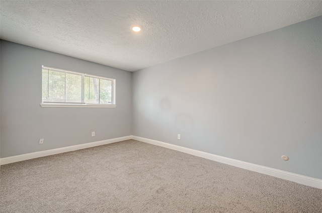 unfurnished room featuring a textured ceiling and carpet floors