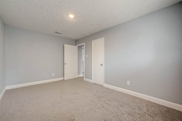 carpeted spare room with a textured ceiling