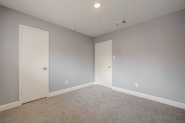 empty room with a textured ceiling and carpet