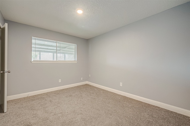 unfurnished room featuring a textured ceiling and carpet