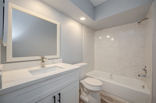 full bathroom with hardwood / wood-style floors, tiled shower / bath, toilet, and vanity