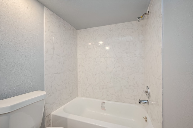 bathroom with toilet and tiled shower / bath