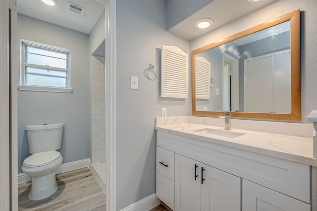 bathroom featuring vanity, toilet, a shower, and wood-type flooring