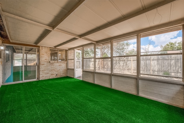 unfurnished sunroom with beam ceiling