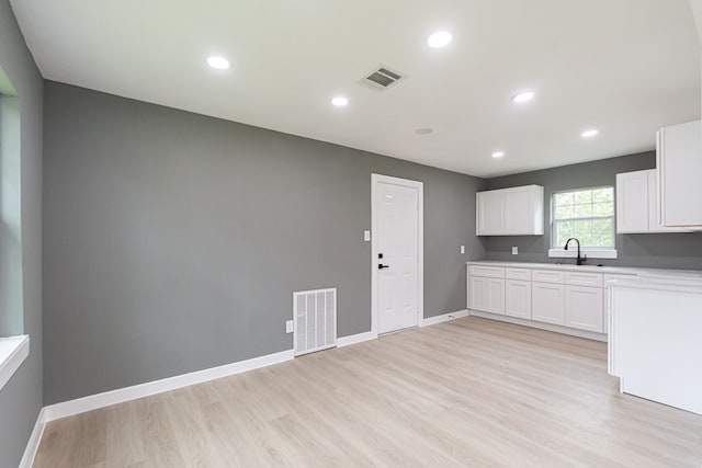 kitchen featuring white cabinetry, light hardwood / wood-style flooring, and sink