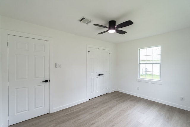 unfurnished bedroom with light hardwood / wood-style flooring, ceiling fan, and a closet