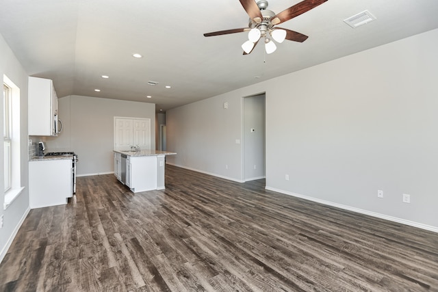 unfurnished living room featuring vaulted ceiling, dark hardwood / wood-style flooring, sink, and ceiling fan