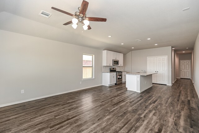 kitchen featuring a kitchen island with sink, appliances with stainless steel finishes, ceiling fan, and dark hardwood / wood-style floors