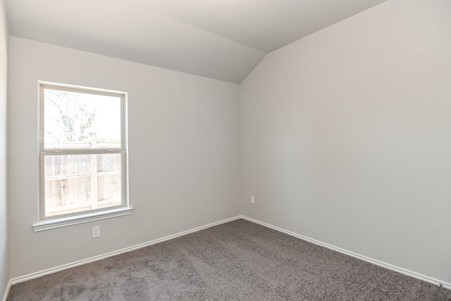 unfurnished room with carpet and vaulted ceiling