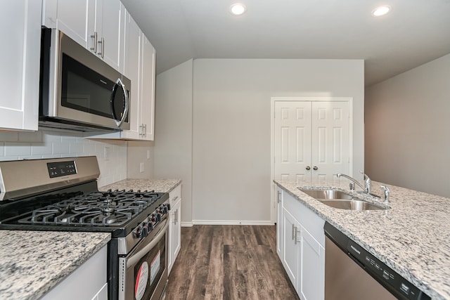 kitchen with appliances with stainless steel finishes, tasteful backsplash, dark wood-type flooring, sink, and white cabinets