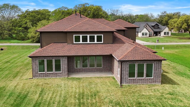 rear view of property featuring a yard and a patio