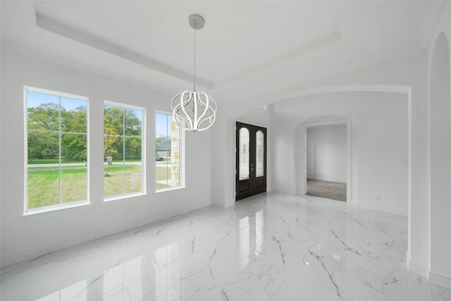 tiled empty room featuring a raised ceiling and an inviting chandelier