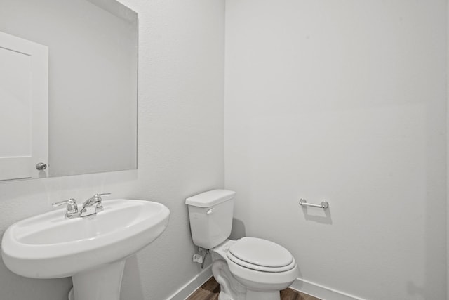 bathroom featuring hardwood / wood-style flooring, toilet, and sink